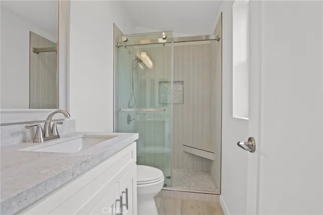 a bathroom with a granite countertop sink toilet and shower