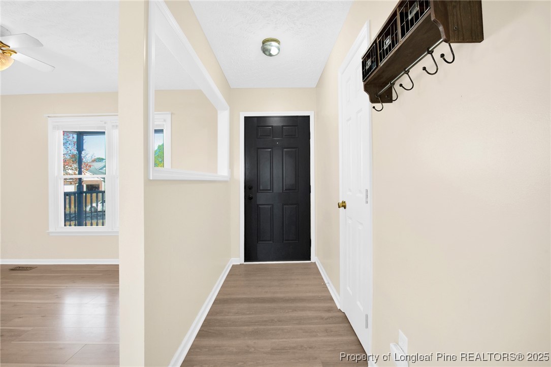 101 2 Hours Court Raeford, NC 28376 - Photo 4 of 30 a view of a hallway with wooden floor and a bathroom