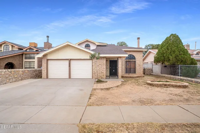 a view of a house with a yard and potted plants