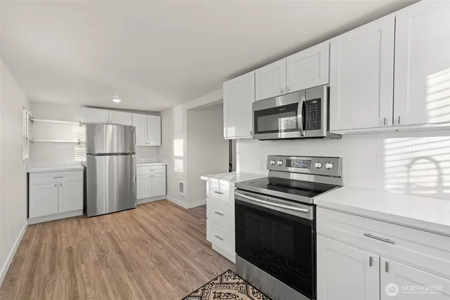 a kitchen with a stove a microwave and a refrigerator