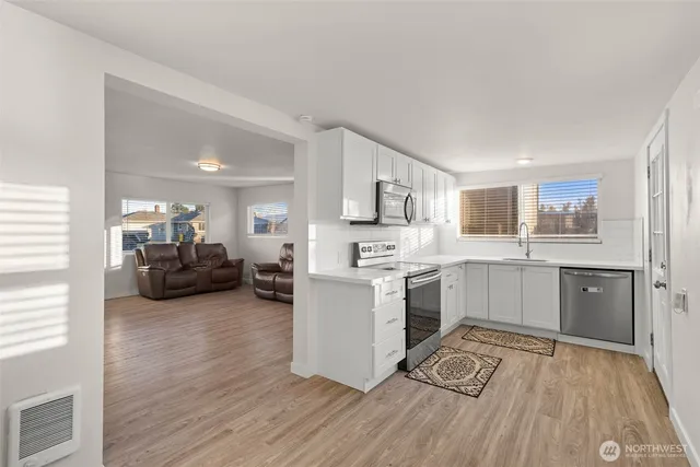 a kitchen with a sink cabinets and wooden floor