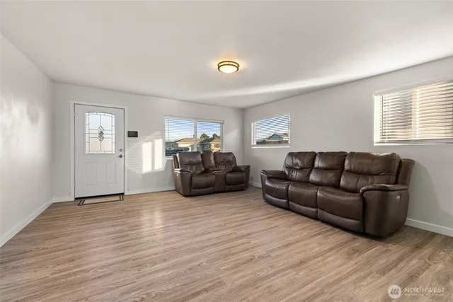 a living room with furniture and a wooden floor