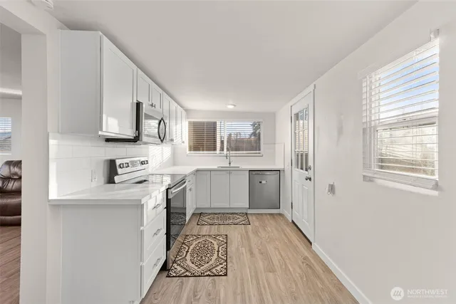 a kitchen with stainless steel appliances granite countertop a refrigerator a sink dishwasher a stove with wooden cabinets and floor