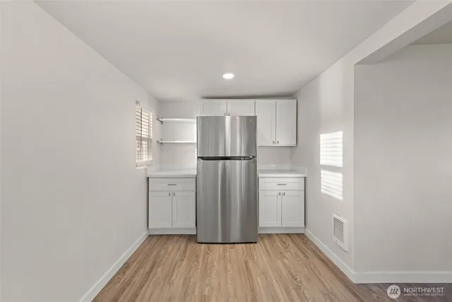 a kitchen with a refrigerator a sink and dishwasher with wooden floor