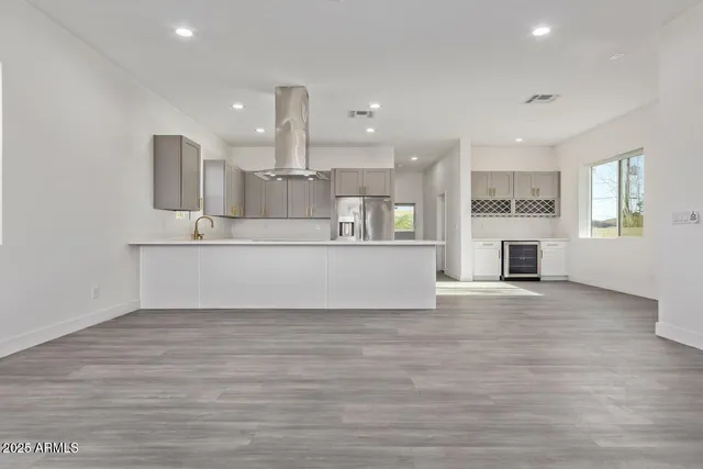 a view of a kitchen with a sink a kitchen island and a window