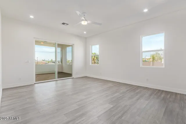 an empty room with wooden floor and a window