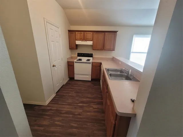 a kitchen with a sink a refrigerator a window