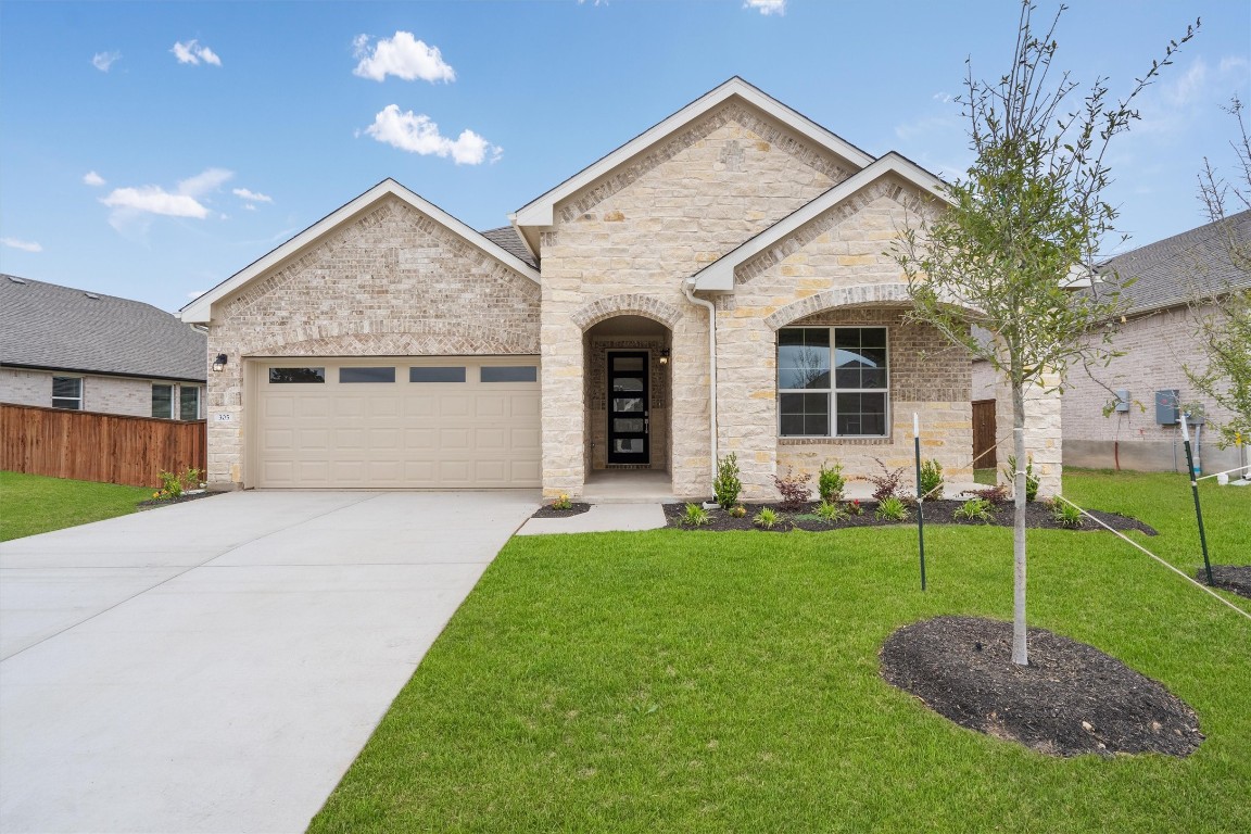 a front view of a house with a yard and garage