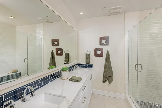 a bathroom with a sink and mirror with bathtub