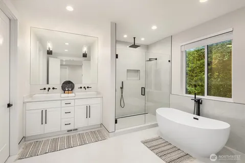 a spacious bathroom with a double vanity sink a toilet a mirror and shower