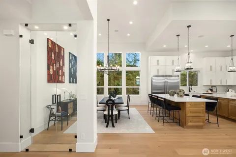 a dining hall with stainless steel appliances kitchen island granite countertop furniture and a view of living room