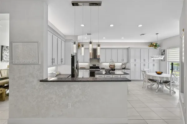 a kitchen with granite countertop a refrigerator stove top oven and sink