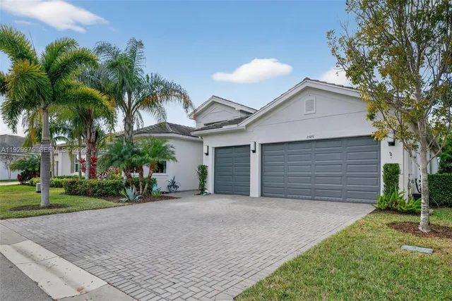 a view of a house with a yard and palm trees