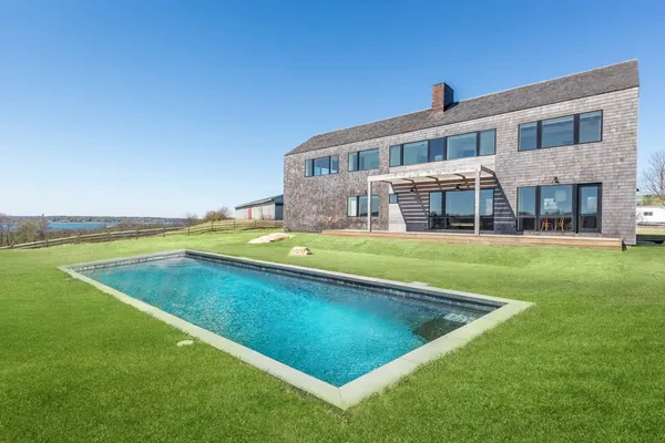 a view of an house with swimming pool and yard