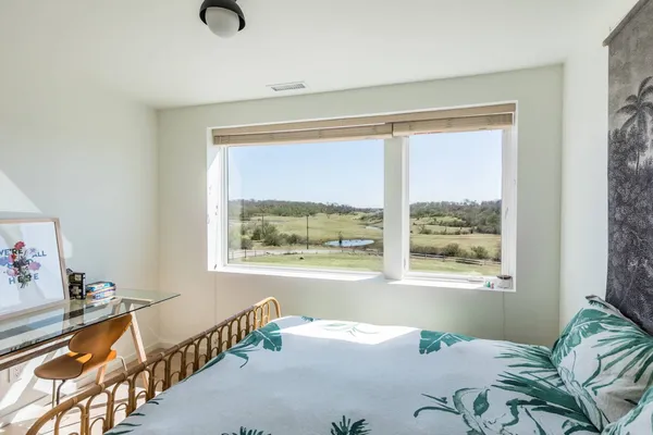 a bedroom with furniture and a large window