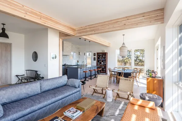 a view of a dining room and livingroom with furniture wooden floor a chandelier