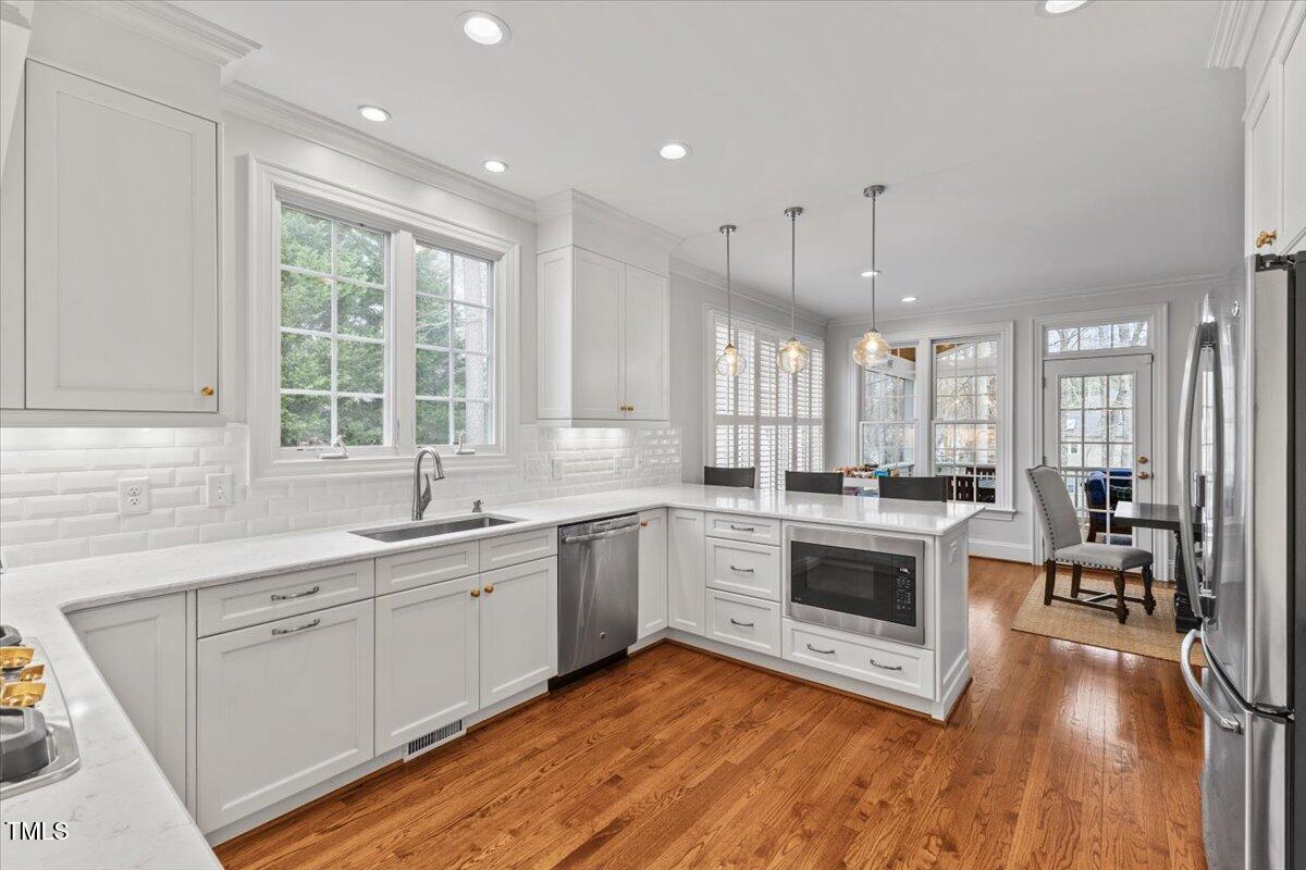 6116 Wilkinsburg Road Raleigh, NC 27612 - Photo 13 of 65 a large kitchen with a large window and white cabinets