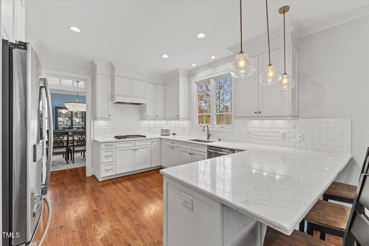 6116 Wilkinsburg Road Raleigh, NC 27612 - Photo 14 of 65 a kitchen with white cabinets and stainless steel appliances