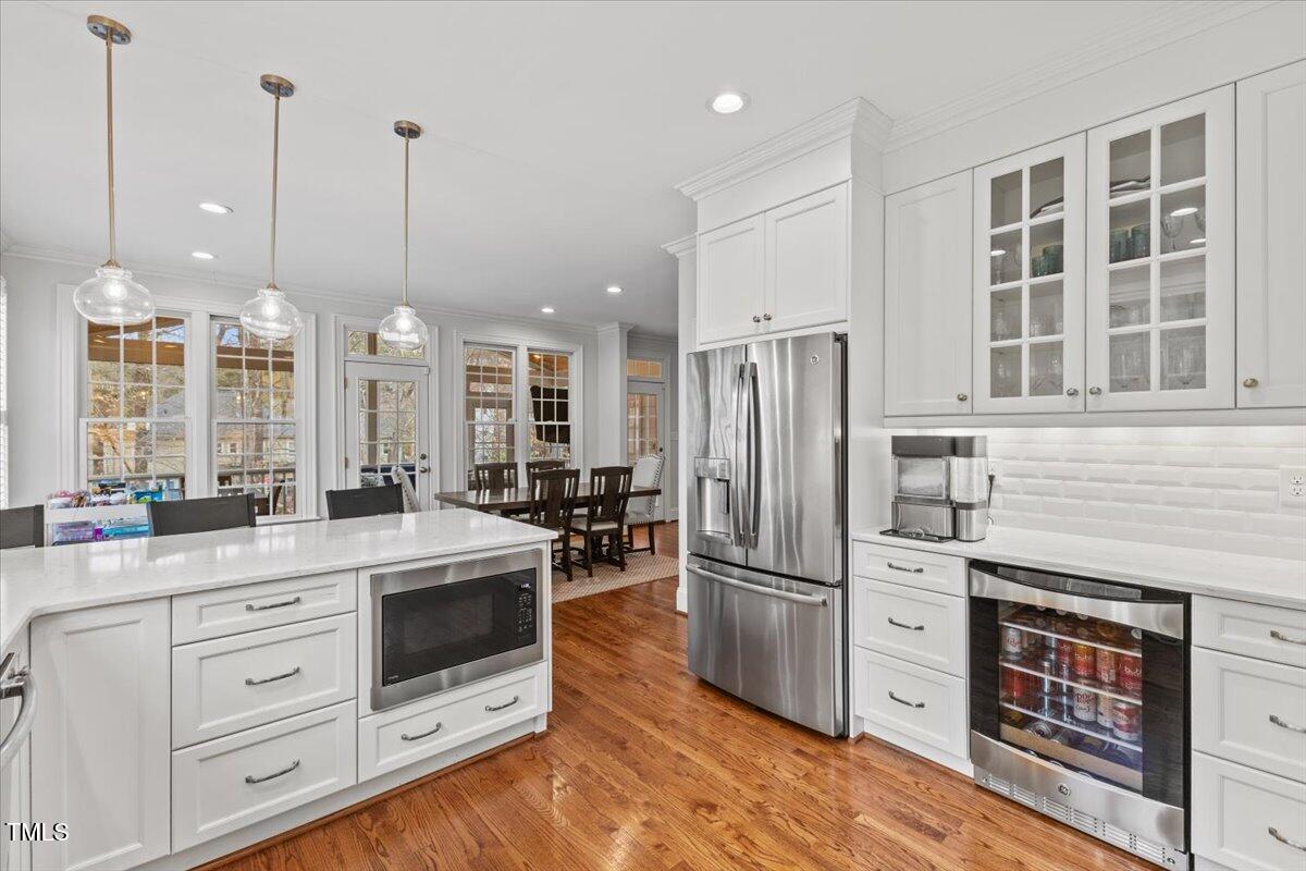 6116 Wilkinsburg Road Raleigh, NC 27612 - Photo 18 of 65 a kitchen with stainless steel appliances kitchen island granite countertop a refrigerator a sink dishwasher a stove and a wooden floors