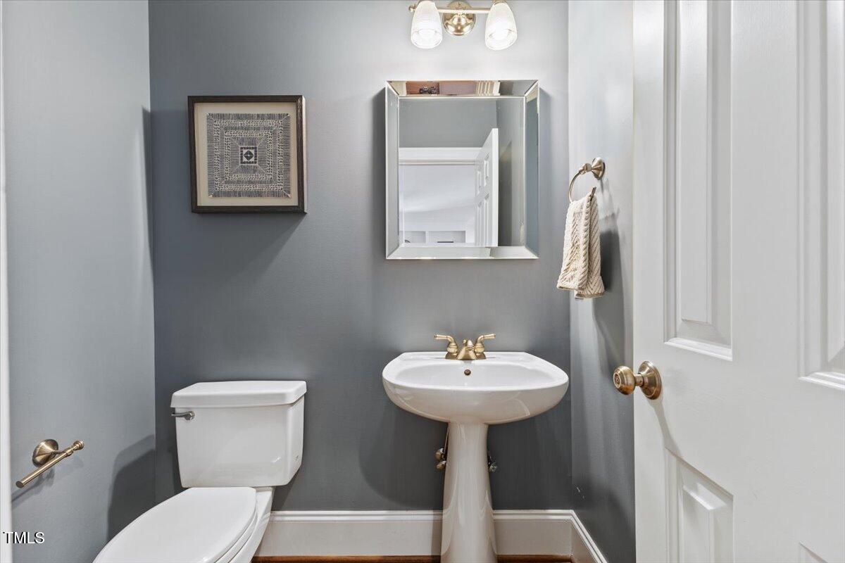 6116 Wilkinsburg Road Raleigh, NC 27612 - Photo 25 of 65 a bathroom with a toilet sink and mirror