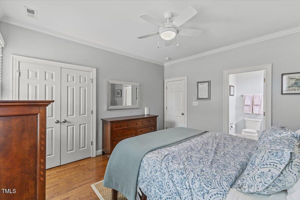 6116 Wilkinsburg Road Raleigh, NC 27612 - Photo 35 of 65 a bedroom with a large bed a chandelier and closet