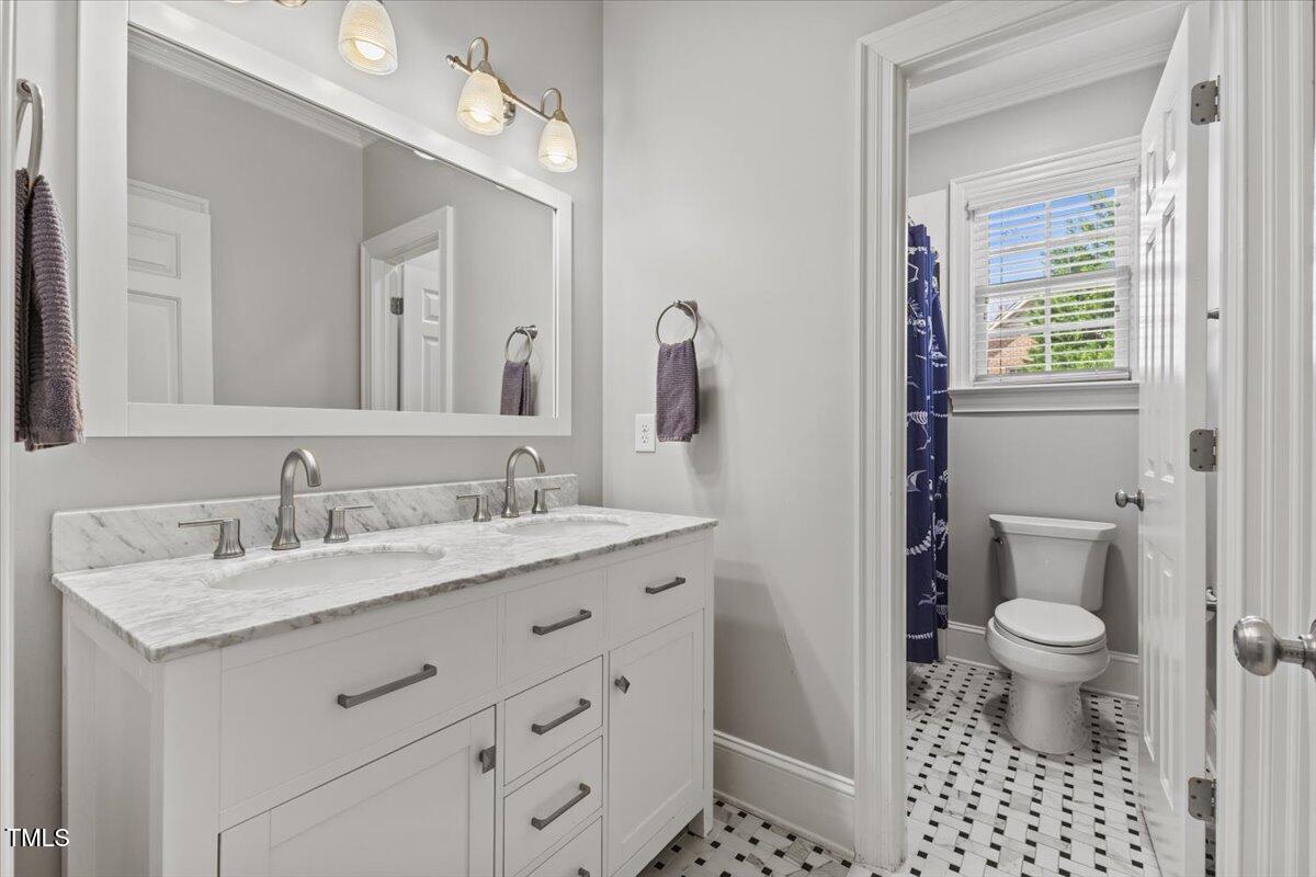 6116 Wilkinsburg Road Raleigh, NC 27612 - Photo 40 of 65 a bathroom with a granite countertop sink a toilet and a mirror