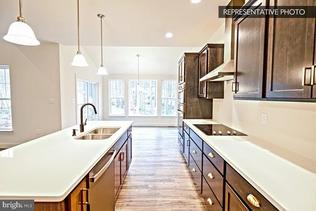 a kitchen with stainless steel appliances granite countertop a sink a stove and a wooden floors