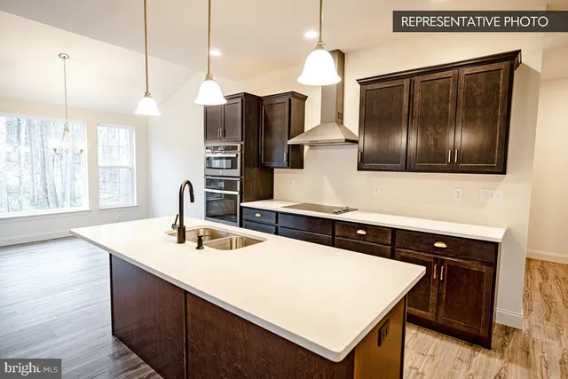 a kitchen with a sink a counter top space and stainless steel appliances