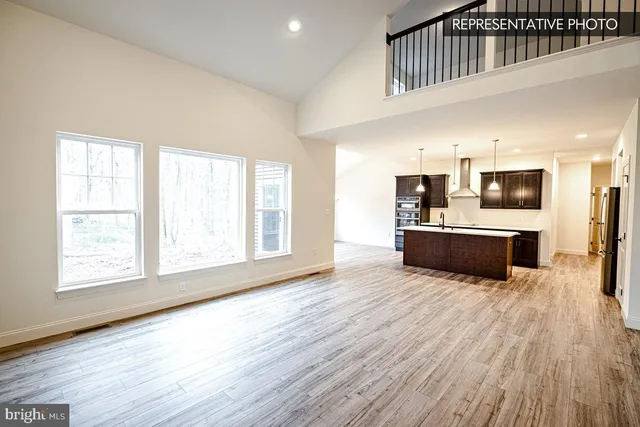 a large white kitchen with a large window a counter space a sink and stainless steel appliances