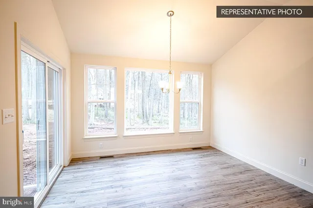 a view of a room with wooden floor and windows