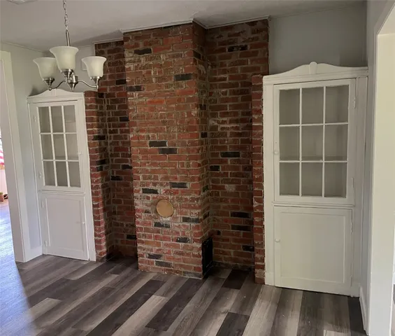 a view of empty room with a door and wooden floor
