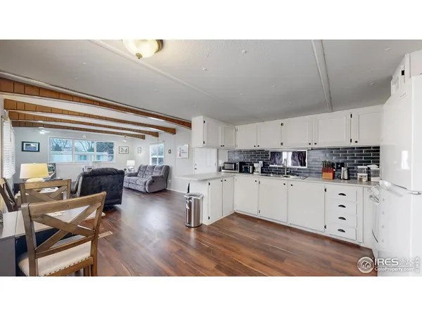 a kitchen with white cabinets and appliances