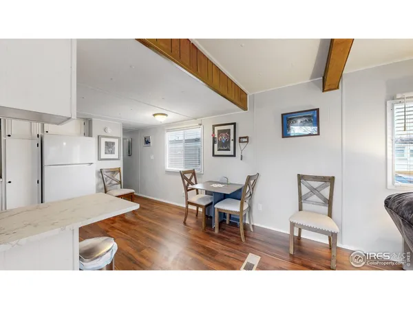 a living room with stainless steel appliances kitchen island granite countertop furniture and a wooden floor