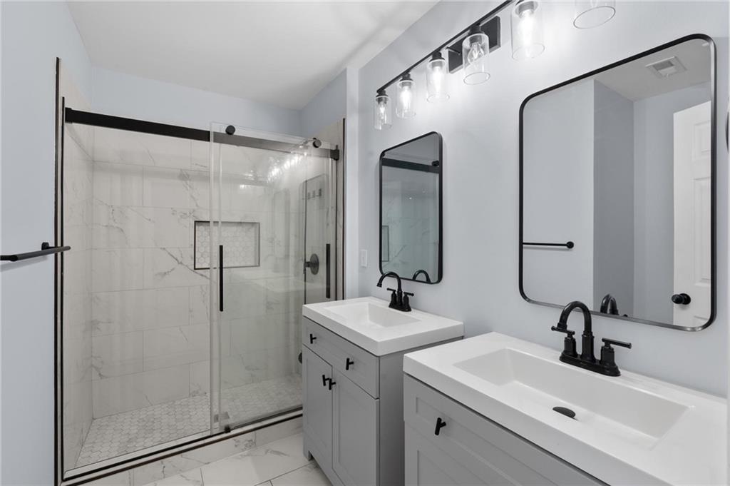 49 Harlan Road Southwest Atlanta, GA 30311 - Photo 23 of 38 a bathroom with a sink mirror and shower