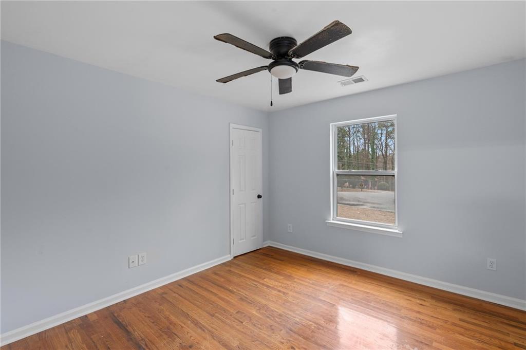 49 Harlan Road Southwest Atlanta, GA 30311 - Photo 30 of 38 an empty room with wooden floor ceiling fan and windows