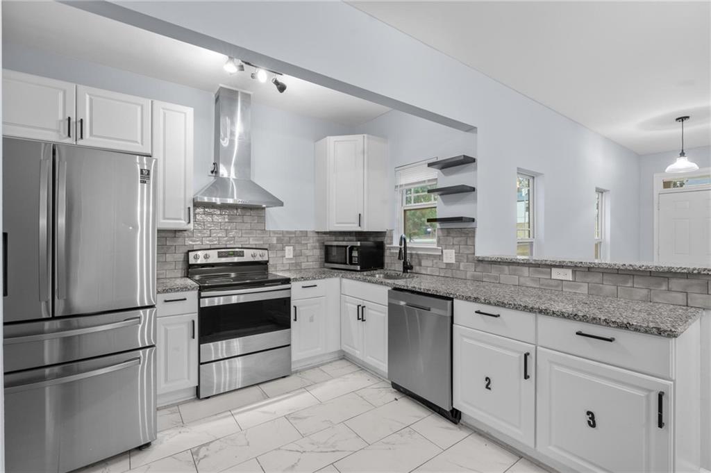 49 Harlan Road Southwest Atlanta, GA 30311 - Photo 8 of 38 a kitchen with granite countertop white cabinets and stainless steel appliances
