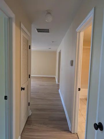 a view of a hallway with wooden floor and staircase