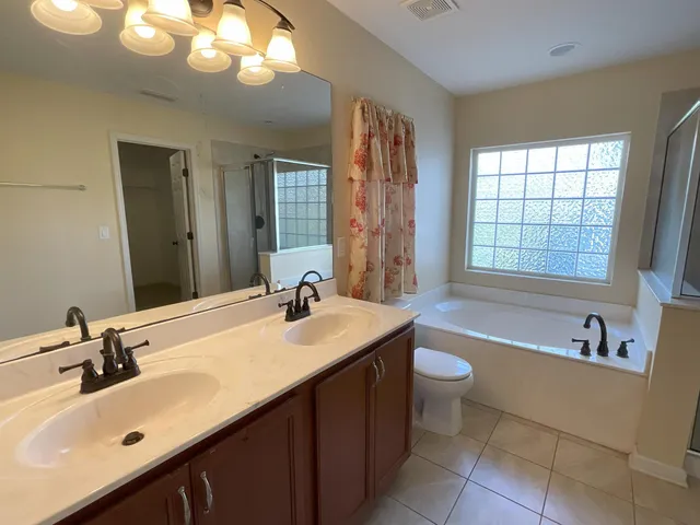 a bathroom with a sink double vanity granite tub and a mirror