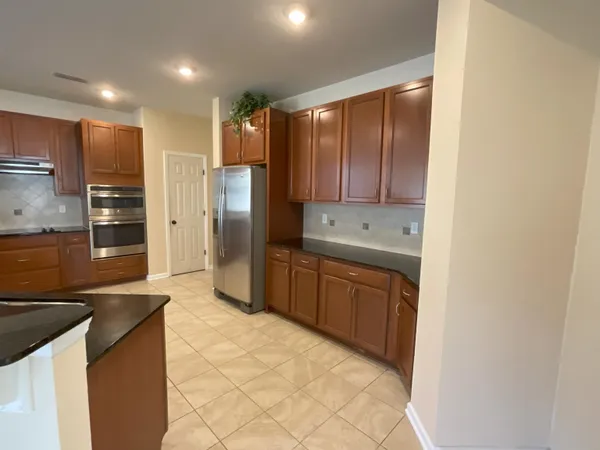 a large kitchen with a refrigerator and a sink