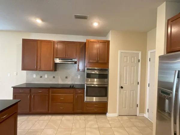a kitchen with stainless steel appliances granite countertop a stove a refrigerator and a sink