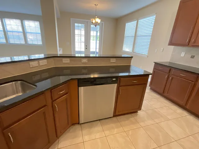 a kitchen with granite countertop a sink a stove and a microwave