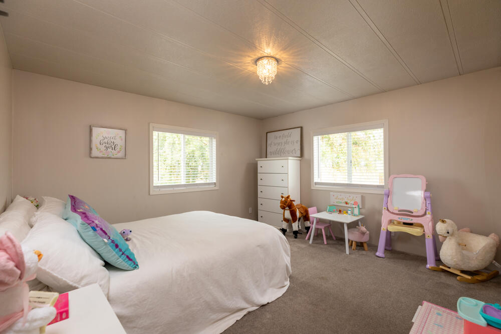 8757 Reeder Road Klamath Falls, OR 97603 - Photo 31 of 34 a bedroom with a bed and a chandelier