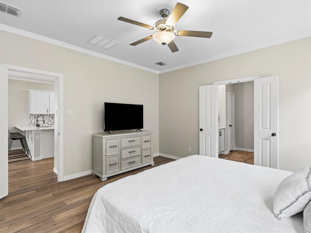 16936 Post Cedar Drive Justin, TX 76247 - Photo 13 of 30 Bedroom featuring wood-finish flooring, a ceiling fan with integrated lighting, and crown molding