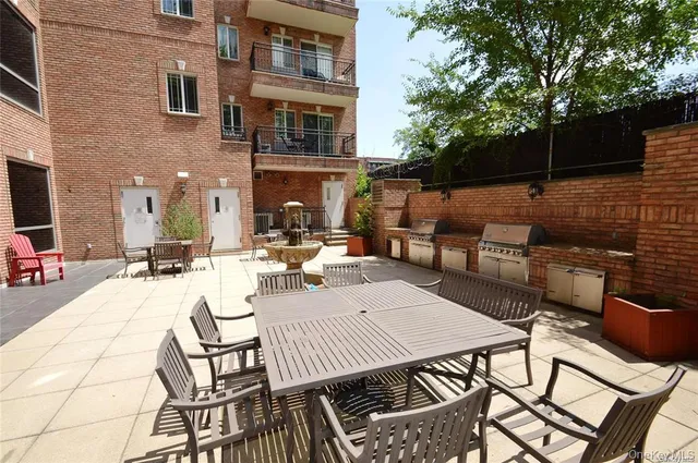 a view of a patio with table and chairs potted plants and a palm tree