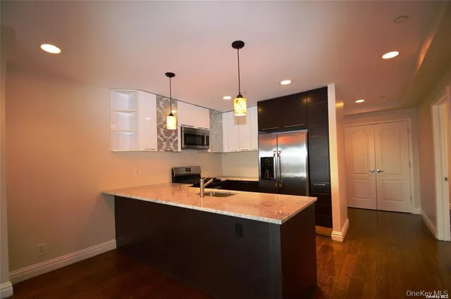 a kitchen with granite countertop a stove a sink a refrigerator and a microwave