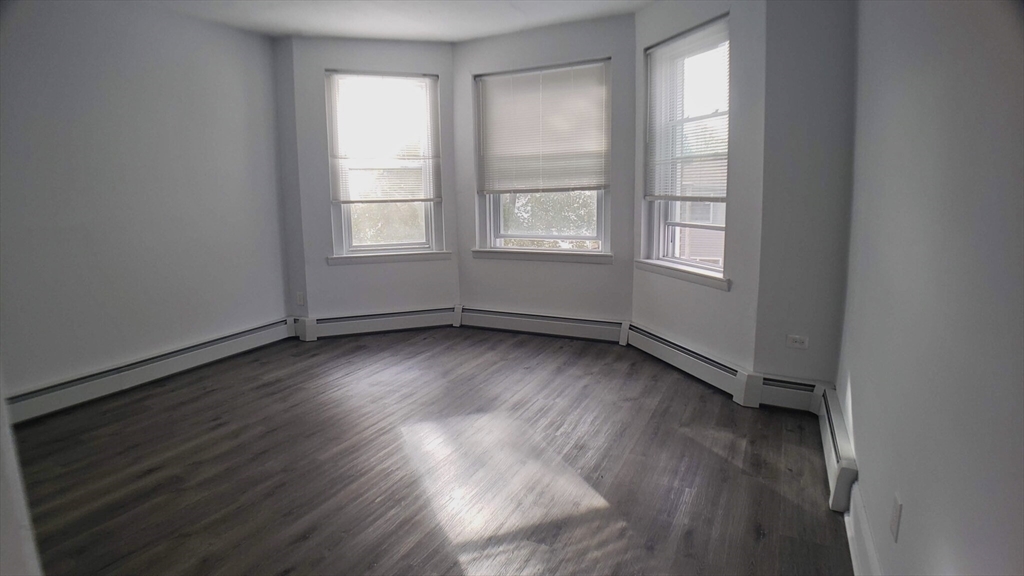 25 Chester Street, Unit 3 Boston, MA 02134 - Photo 11 of 14 an empty room with wooden floor and windows