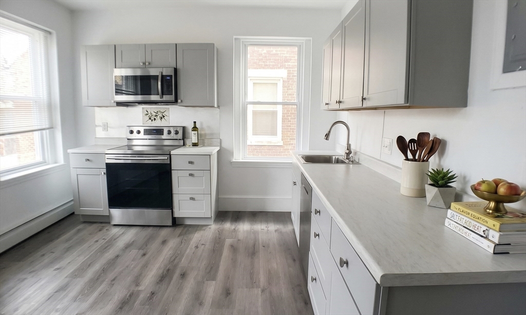 25 Chester Street, Unit 3 Boston, MA 02134 - Photo 2 of 14 a kitchen with stainless steel appliances granite countertop a sink stove and refrigerator