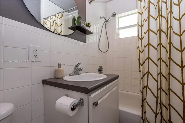 a bathroom with a sink a mirror and shower
