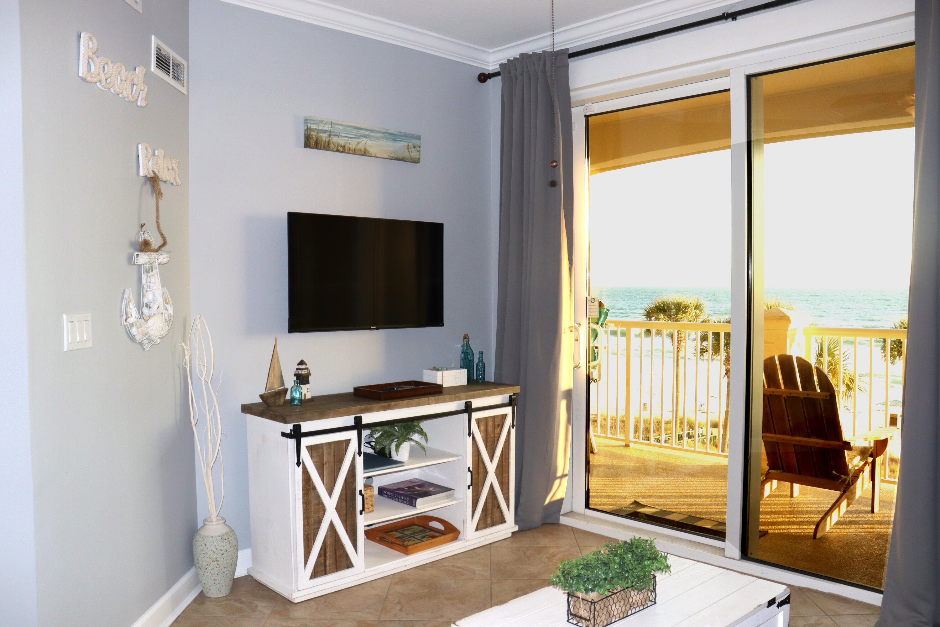 11807 Front Beach Road, Unit 1402 Panama City Beach, FL 32407 - Photo 12 of 37 a living room with a flat screen tv and a floor to ceiling window