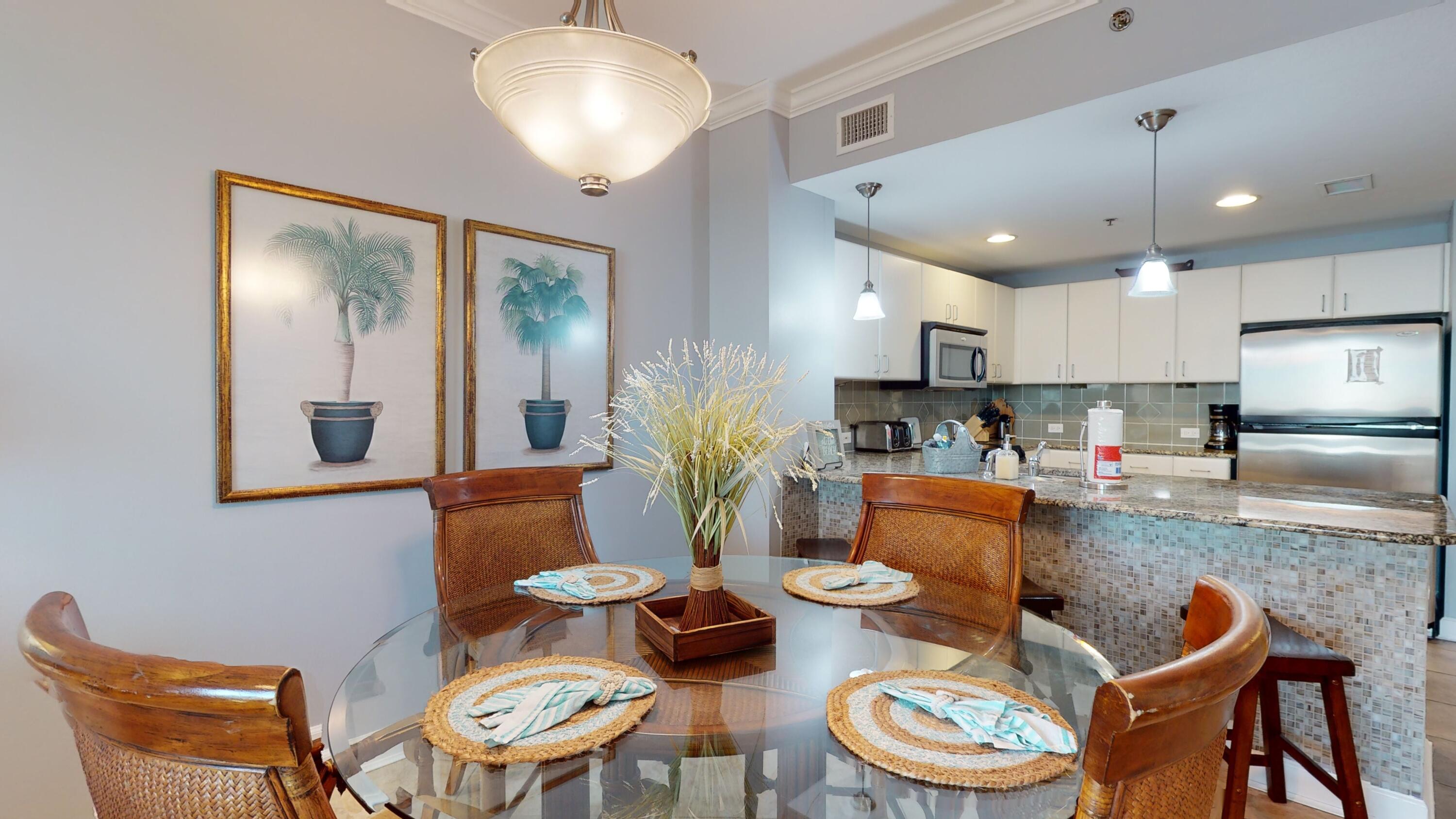 11807 Front Beach Road, Unit 1402 Panama City Beach, FL 32407 - Photo 7 of 37 a kitchen with stainless steel appliances kitchen island granite countertop a dining table and chairs